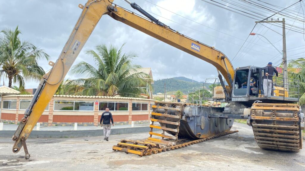 Na tarde de ontem (24/9) duas máquinas escavadeiras hidráulicas modelo anfíbia chegaram ao canal de Ponta Negra, em Maricá, para dar início ao trabalho de desassoreamento da entrada do canal “GALETA”. A ação é realizada pela autarquia Serviços de Obras de Maricá (SOMAR) em parceria com a Secretaria de Pesca. O serviço atende a uma demanda antiga da comunidade pesqueira local. Na maré baixa, a região apresenta grande dificuldade de navegabilidade devido ao acúmulo de pedras e sedimentos, que dificultam a passagem das embarcações. Segundo o Secretário de pesca, Alexandre Rodrigues de Oliveira (Xandi de Bambuí), o objetivo da ação é deixar o canal navegável, as pedras serão realocadas e com isso vai melhorar o ir e vim dos pescadores, evitando acidentes. Serão utilizadas duas máquinas escavadeiras hidráulicas modelo anfíbia de 30 toneladas, que alcança aproximadamente 15 metros de profundidade. Diferente das escavadeiras convencionais, os modelos anfíbias flutuam e podem operar em áreas alagadas e de difícil acesso, garantindo maior eficiência em canais e lagoas que não possuem margem para máquinas terrestres. A chegada dos equipamentos foi bem recebida pela população. Moradores e pescadores destacaram a importância da obra para a economia local e para o meio ambiente. “É um trabalho que esperávamos há muito tempo. Agora, vamos poder sair para o mar com mais tranquilidade”, disse um pescador da região. Com a intervenção, a expectativa é que o canal volte a oferecer condições adequadas de navegação, beneficiando diretamente os trabalhadores do mar e fortalecendo a vida lagunar de Maricá.
