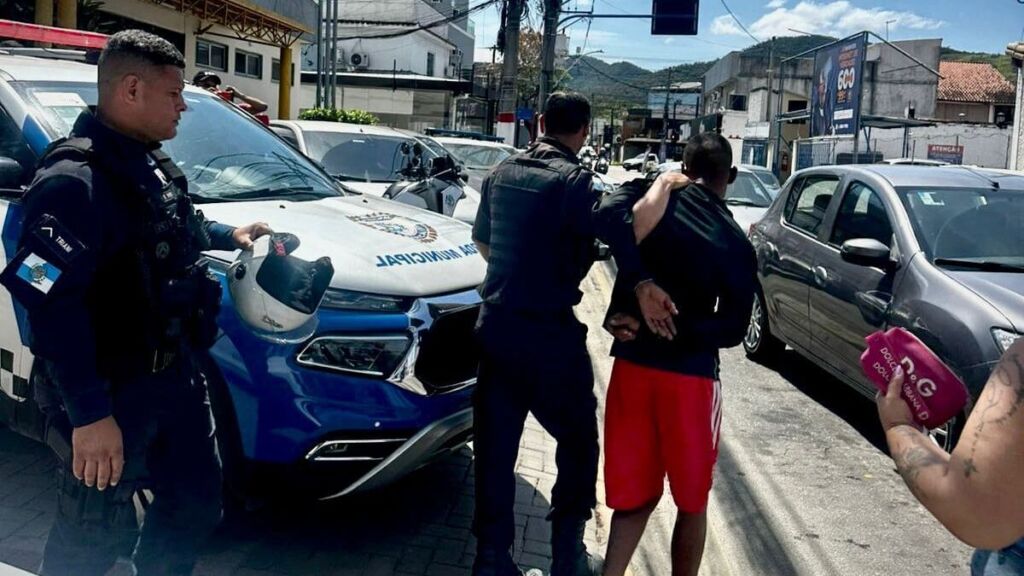 A Secretaria de Segurança Cidadã em parceria com o Programa Estadual de Integração na Segurança (PROEIS), realizou mais uma importante ação de combate à criminalidade no município. Na manhã de sexta-feira (03/10), agentes que realizavam patrulhamento preventivo na orla da Lagoa de Araçatiba, nas proximidades do Boqueirão, foram alertados pelo Centro Integrado de Operações em Segurança Pública (Ciosp) sobre uma motocicleta suspeita de envolvimento em crimes na cidade. O veículo, uma Yamaha Fazer 150 vermelha, estava sendo conduzido por um indivíduo com as características informadas pelo Ciosp: bermuda vermelha, casaco preto e mochila. Com apoio de outras equipes, foi montado um cerco tático que resultou na abordagem do suspeito próximo à Praça Garota de Maricá, no bairro Araçatiba. Durante a ação, o homem tentou se desfazer da mochila, jogando-a em um terreno. Na revista, foram encontrados um rádio transmissor em funcionamento e uma base para o equipamento. O suspeito confessou ter saído de um “plantão” do tráfico de drogas no Morro do Castro, em Niterói, e indicou o local onde havia abandonado a motocicleta, posteriormente localizada por uma equipe da Guarda Municipal. O indivíduo foi conduzido à 82ª Delegacia de Polícia (Maricá), onde os materiais apreendidos foram apresentados. Após verificação, foi constatado que ele possuía 36 anotações criminais e já havia sido preso 11 vezes. Nesta ocorrência, foi autuado por furto, violação de domicílio e resistência, sendo encaminhado à 76ª DP (Niterói).